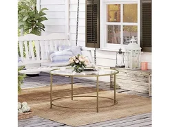 Mesa de centro redonda Valora con estructura de acero dorado y tablero de cristal