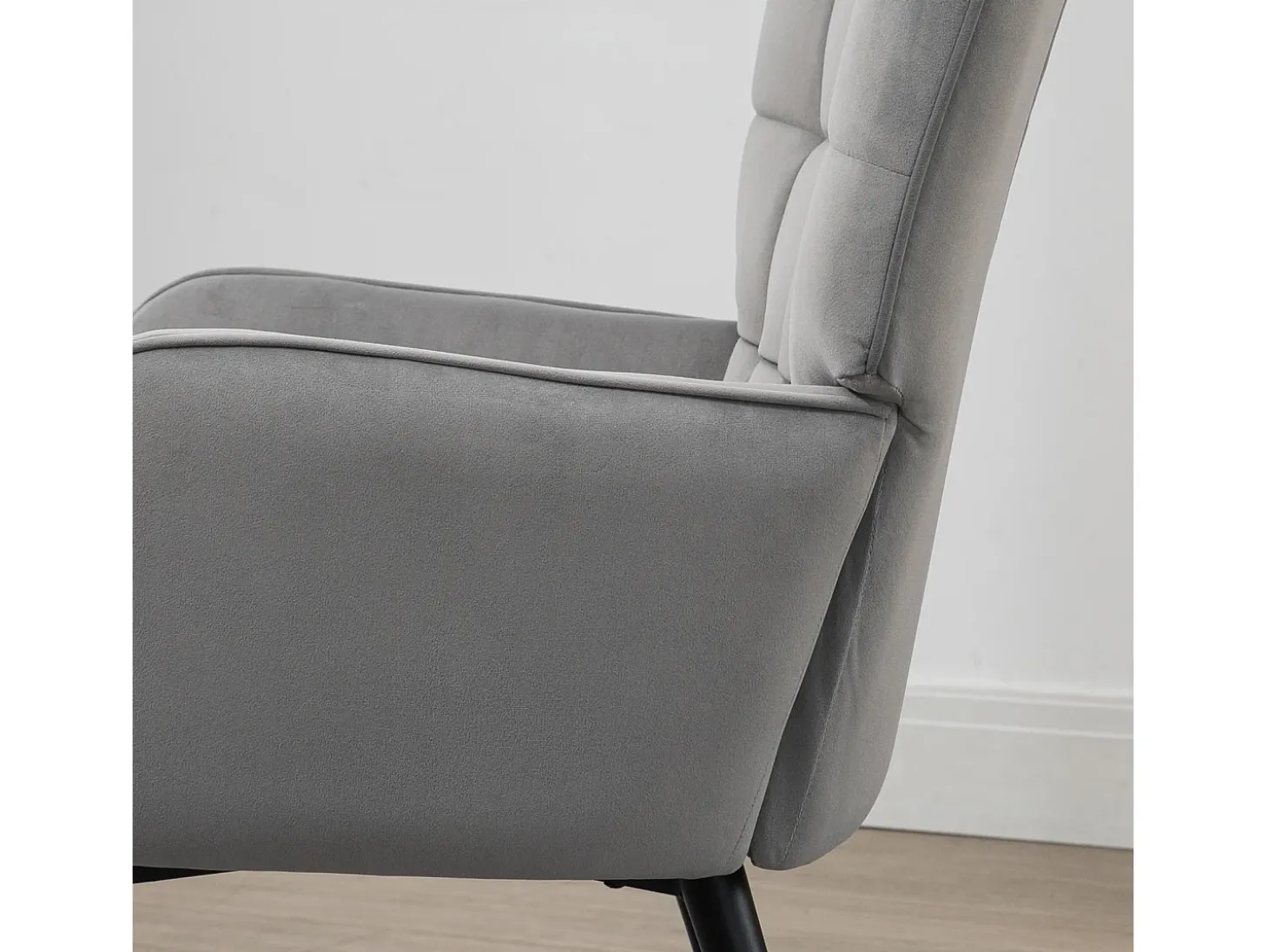 Sillón con taburete en terciopelo gris claro, patas de metal negro.
