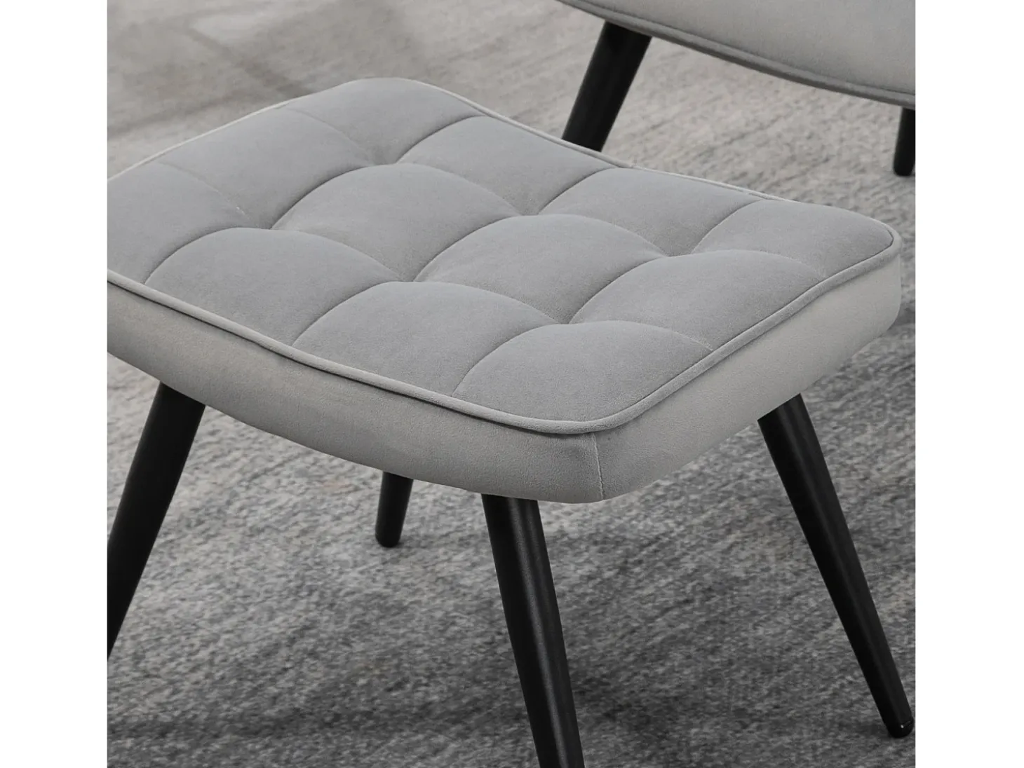 Sillón con taburete en terciopelo gris claro, patas de metal negro.